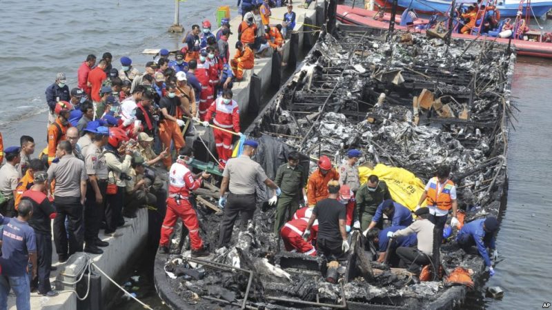 Petugas mencari korban dalam kapal fery Zahro Express yang terbakar (foto KKC/VOA Indonesia/AP/Rhana Ananda)