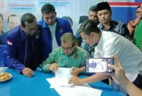 Bupati H.Mursini menandatangani berkas pendaftaran calon Pilkada di Sekretariat Partai Demokrat Kuansing, Jumat (15/11/2019) malam. (foto Istimewa)