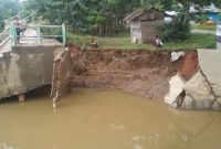 Bantaran muara Sungai Parit Desa Koto Taluk mengalami abrasi. Akibatnya loneng bagian bawah jembatan menuju Taman Kota Pulau Bungi ambrol  (Foto istimewa)