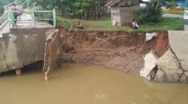Bantaran muara Sungai Parit Desa Koto Taluk mengalami abrasi. Akibatnya loneng bagian bawah jembatan menuju Taman Kota Pulau Bungi ambrol  (Foto istimewa)