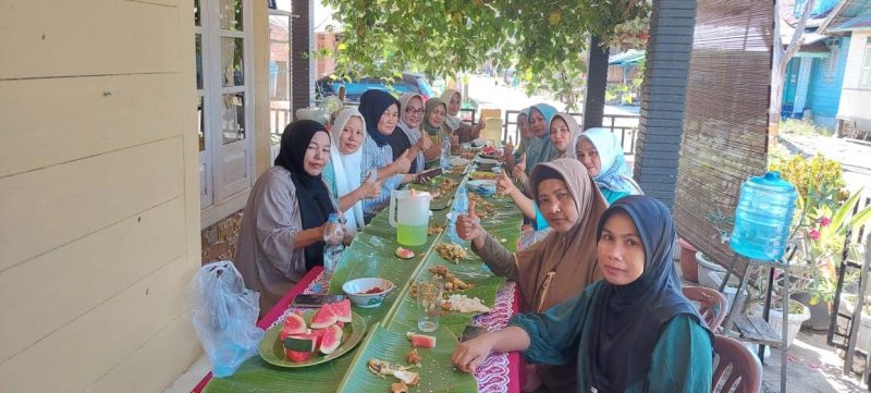 Emak-emak Desa Koto Taluk menyantap sajian di atas daun pisang (foto KuansingKita)
